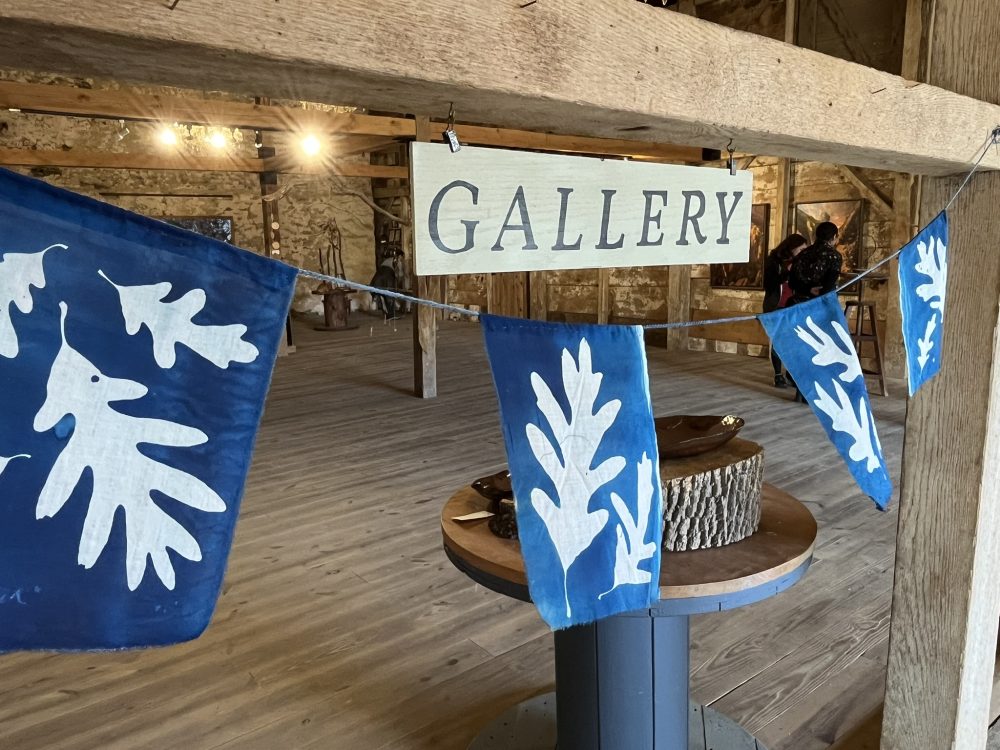 gallery sign with blue and white cyanotype flags of oak leaves